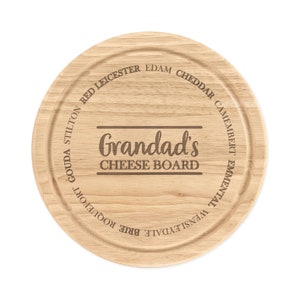 May include: A round wooden cheese board with the text "Grandad's Cheese Board" engraved in the centre. The board is surrounded by a ring of cheese names, including Cheddar, Edam, Gouda, and Brie.