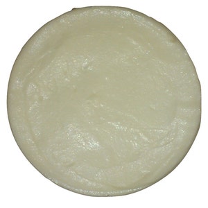 May include: A round, white, solid bar of soap.