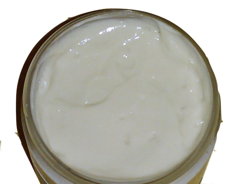 May include: A close-up of a white, creamy substance in a clear glass jar.