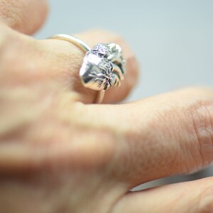May include: A silver ring with a detailed anatomical heart design.