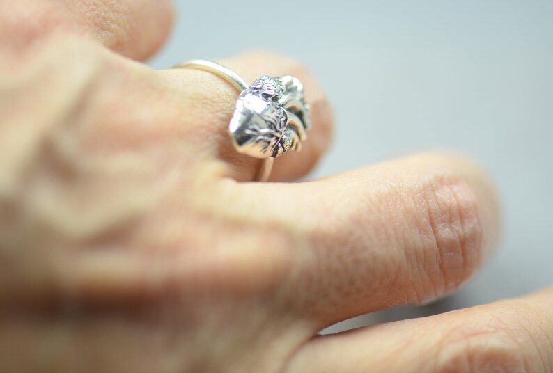 May include: A silver ring with a detailed anatomical heart design.