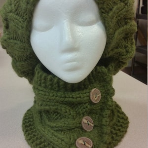 May include: A green knitted hat and neck warmer set with three wooden buttons.
