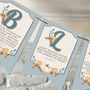 May include: A blue and white banner with fall-themed illustrations and bible verses. The banner reads "Blessed be the God and Father of our Lord Jesus Christ, who has blessed us in Christ with every spiritual blessing in the heavenly places. Ephesians 1:3", "Light shines on the righteous and joy on the upright in heart. Psalm 97:11", and "Every good gift and perfect gift is from above, coming down from the Father of lights, with whom there is no variation or shadow due to change. James 1:17".