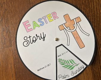 May include: A colorful paper wheel with the words "Easter Story" and "Palm Sunday" on it. The wheel is divided into sections, each with a different image related to the Easter story. One section shows a cross with a crown of thorns, another shows a palm branch, and another shows the text "Matthew 21:28:7".