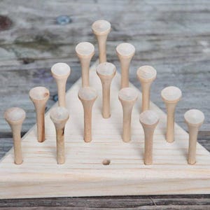May include: A wooden triangular game board with 15 wooden pegs arranged in a pyramid shape. The pegs are all the same size and color, and they are placed in a pattern that resembles a triangle.