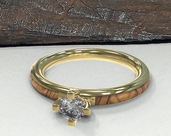 May include: A gold ring with a wooden band and a clear diamond in the center.