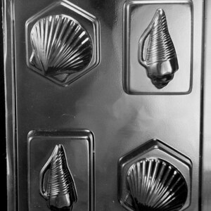 May include: A plastic mold for making chocolate seashells. The mold has four cavities, two shaped like seashells and two shaped like conch shells.