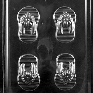 May include: A clear plastic mold for making chocolate flip flops. The mold has four cavities, each shaped like a flip flop with a flower design.