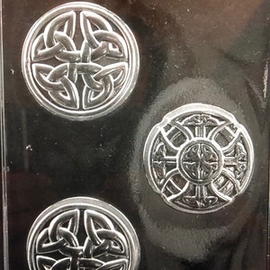 以下が含まれることがあります： 3つの異なるケルトの結び目のデザインを施したチョコレートキャンディーを作るための型。型は濃いグレーの光沢のある素材で作られています。