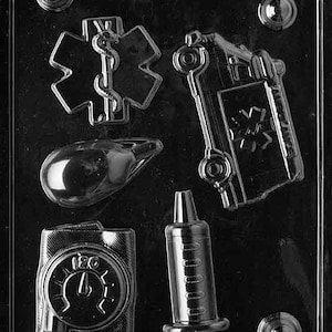 May include: A black and white plastic mold for making chocolate candies. The mold features five different designs: a medical symbol, a stethoscope, a syringe, a blood pressure cuff, and an ambulance. The mold is labeled "Fill of the Party 507".