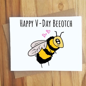 Puede incluir: Una tarjeta de felicitaci&oacute;n blanca con el texto "HAPPY V-DAY BEEOTCH" y una ilustraci&oacute;n de abeja de dibujos animados. La abeja es amarilla y negra con alas grises y dos corazones rosas encima. La tarjeta est&aacute; en un sobre marr&oacute;n.