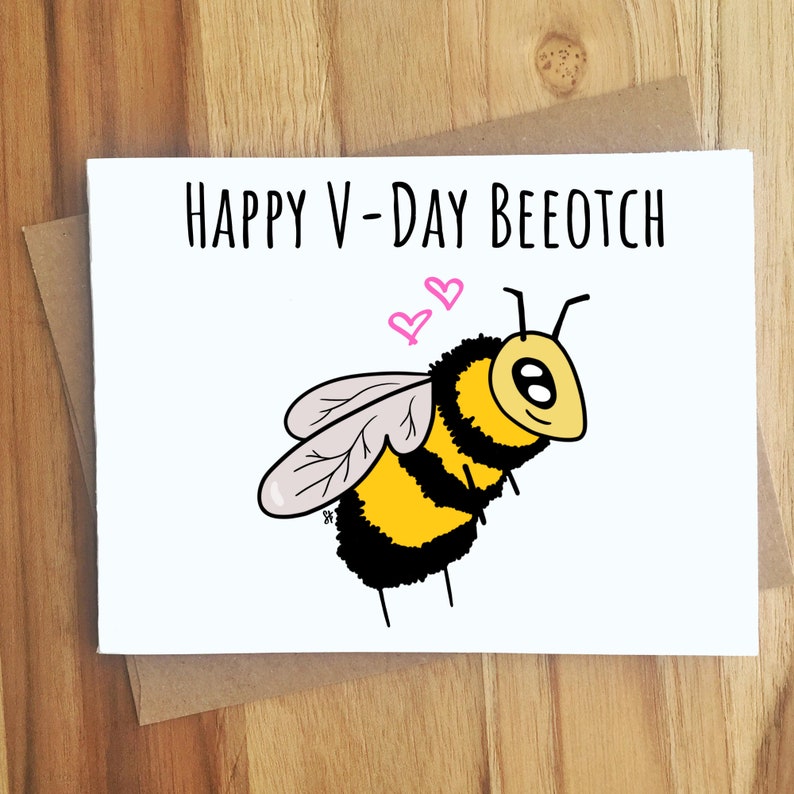 Puede incluir: Una tarjeta de felicitaci&oacute;n blanca con el texto "HAPPY V-DAY BEEOTCH" y una ilustraci&oacute;n de abeja de dibujos animados. La abeja es amarilla y negra con alas grises y dos corazones rosas encima. La tarjeta est&aacute; en un sobre marr&oacute;n.