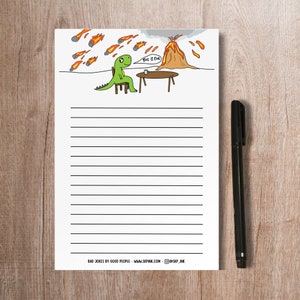 May include: A green dinosaur cartoon character sitting on a chair with a cup of coffee, saying "This is fine" in a speech bubble. A volcano erupts in the background with lava flowing down the sides. The image is on lined paper with the text "Bad Jokes by Good People - www.skp.ink.com - @skp.ink" at the bottom.