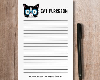 May include: A white lined notepad with a black and white cat wearing blue glasses and the text "CAT PURRRSON" at the top. The bottom of the notepad says "BAD JOKES BY GOOD PEOPLE - WWW.SKPINK.COM - @SKP_INK".