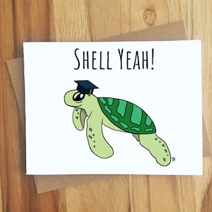 May include: A white card with a green sea turtle wearing a black graduation cap. The text "SHELL YEAH!" is written in black above the turtle.