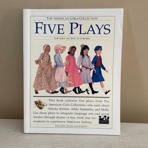 May include: A white softcover book titled The American Girls Collection: Five Plays for Girls and Boys to Perform. The cover features an illustration of five children in historical clothing and text describing the contents, including plays about Felicity, Kirsten, Addy, Samantha, and Molly.