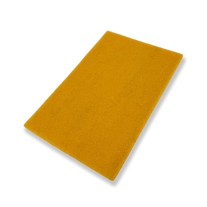 May include: A rectangular, mustard-yellow felt sheet. The felt has a soft, textured appearance and is angled slightly, casting a subtle shadow. The item is isolated on a white background.