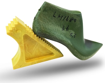 May include: A green shoe last with the text "LH/680 36 5.5" written on it. The last is resting on a yellow plastic shoe sizing tool.