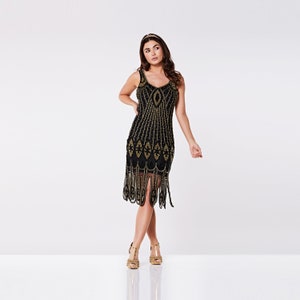 May include: A black beaded flapper dress with gold embellishments and a fringe hem. The dress has a sleeveless design and a V-neckline.