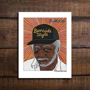May include: A rectangular art print featuring a portrait of an older individual with gray hair and a beard, wearing a black baseball cap with the text Burnside Style in yellow. The background consists of orange and white radiating lines.