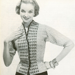 May include: A black and white knitted cardigan with a geometric pattern on the front. The cardigan has a V-neck and three-quarter sleeves.