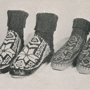 May include: Four black and white patterned knitted slipper socks. The socks have a geometric design and are made of a thick, warm material.
