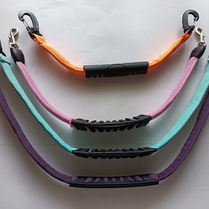 May include: Four multi-colored dog leashes with black handles and clips. The leashes are purple, teal, pink, and orange. Each leash has a black handle with a textured grip for comfort. The clips are silver and black.