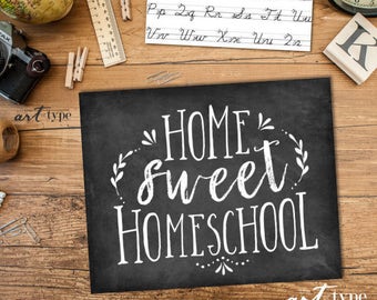 May include: A black chalkboard-style sign with the words "HOME SWEET HOMESCHOOL" in white script. The sign is surrounded by school supplies, including a globe, a vintage camera, and a ruler. The background is a wooden surface.