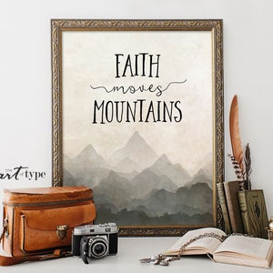 Könnte beinhalten: Ein gerahmter Druck mit einer Aquarell-artigen Berglandschaft und dem Text "FAITH moves MOUNTAINS".