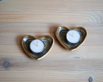 A pair of gray heart shaped candle holders.