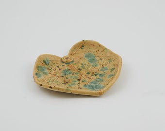 May include: A ceramic leaf-shaped dish with a speckled glaze in shades of yellow, brown, and green.