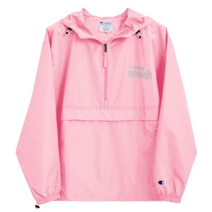 May include: A pink Champion brand windbreaker with a zipper closure and a small graphic of a car on the front. The windbreaker has a hood and a kangaroo pocket.