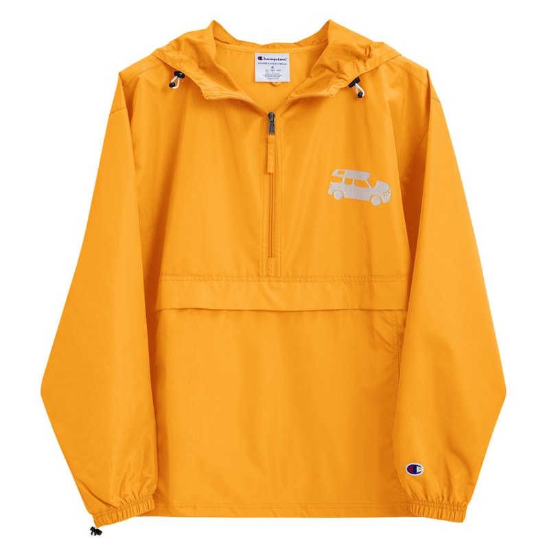 May include: A yellow Champion brand windbreaker jacket with a zipper closure and a small white graphic of a car on the front. The jacket has a hood and a kangaroo pocket.