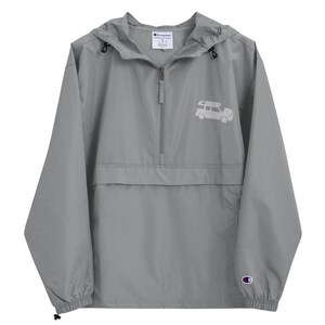 May include: A gray Champion brand hooded windbreaker with a zipper closure and a white silhouette of a car with a roof rack on the front. The windbreaker has a drawstring hood and elastic cuffs.