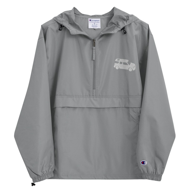 May include: A gray Champion brand hooded windbreaker with a zipper closure and a white silhouette of a car with a roof rack on the front. The windbreaker has a drawstring hood and elastic cuffs.