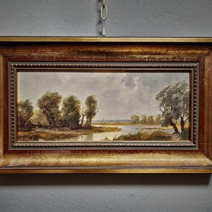 Vintage landscape oil painting featuring a panoramic European countryside, ideal for rustic farmhouse decor and mid-century wall design. This signed original artwork by a German artist captures a tranquil nature scene with warm tones and textured brushstrokes Perfect for collectible fine art enthusiasts and lovers of classic wall decor, this piece suits living room wall art, offices, and refined interiors. A thoughtful gift for art lovers, collectors and those who value original artwork for sale