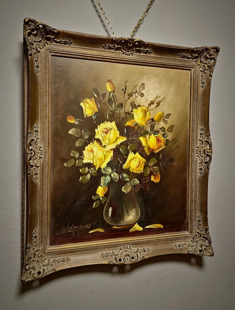 A refined large vintage oil painting of yellow roses still life, presented in a glass vase with luminous petals against a deep shadowed background, reflecting mid century European floral art traditions, with rich texture and balanced composition, ideal for collectible fine art, original artwork for sale, and botanical interior decor, suitable for living room statement wall, dining space styling, or as a gift for collectors, interior designers, or admirers of classic floral compositions