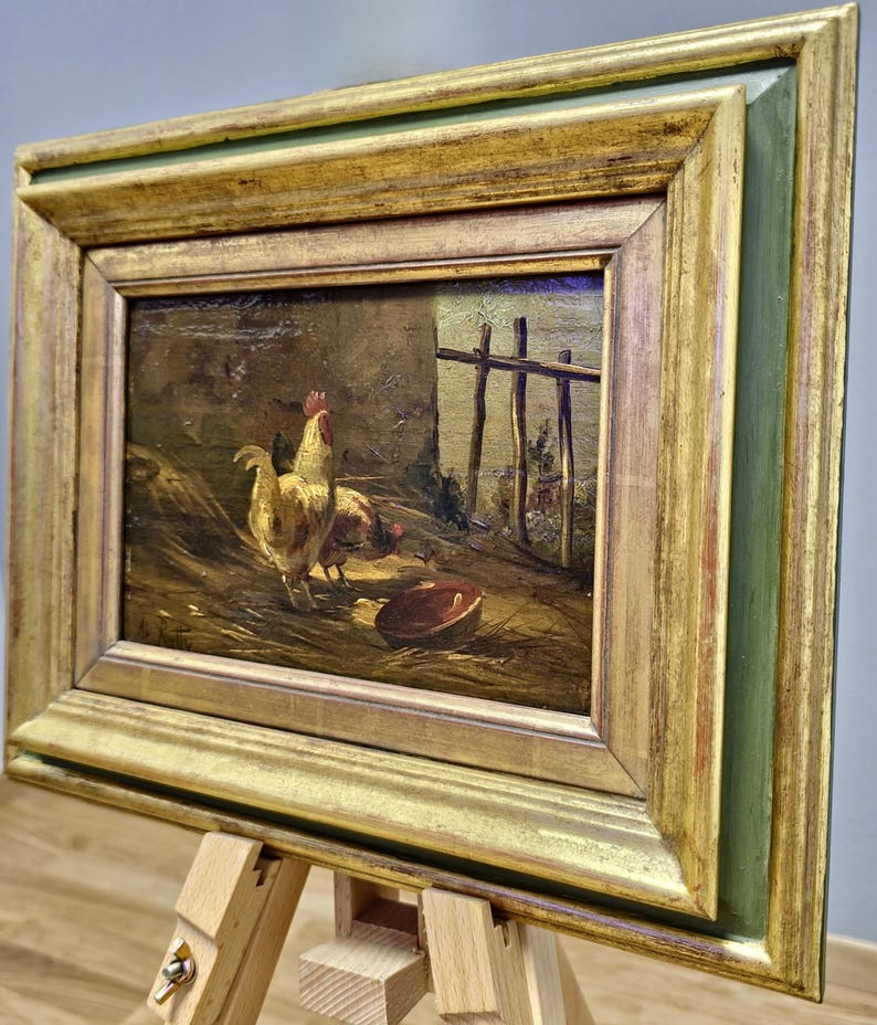 Peut inclure: Peinture encadr&eacute;e ancienne repr&eacute;sentant des poulets dans une ferme. L'&oelig;uvre pr&eacute;sente un coq et des poules pr&egrave;s d'une cl&ocirc;ture en bois et d'un bol. Le cadre dor&eacute; avec un bord int&eacute;rieur vert ajoute &agrave; l'esth&eacute;tique vintage.