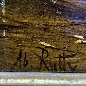 Peut inclure: Gros plan sur une peinture encadr&eacute;e &agrave; l'aspect textur&eacute; et vieilli. L'&oelig;uvre pr&eacute;sente un m&eacute;lange de teintes marron, dor&eacute;es et bleues. La signature de l'artiste, "Ab. Rutty", est visible &agrave; l'encre noire dans le coin inf&eacute;rieur gauche.