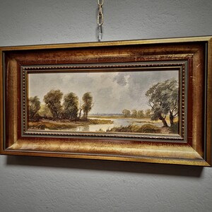 Hand painted landscape artwork depicting a German pastoral view, created in the 1950s with delicate tones and fine detail. This vintage oil painting is a collectible wall art piece ideal for living rooms, hallways, or offices. Its timeless composition adds elegance to rustic and traditional decor styles. Makes a meaningful gift for family members, friends, or coworkers during Christmas, anniversaries, weddings, or retirement celebrations. A must-have for fans of original European decor.