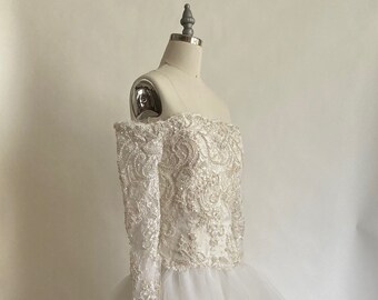 Vestido de novia estilo gala con mangas largas, hombros