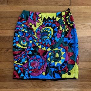 Puede incluir: Una falda de lentejuelas colorida con un patrón geométrico en tonos de azul, verde, amarillo, rojo y rosa.