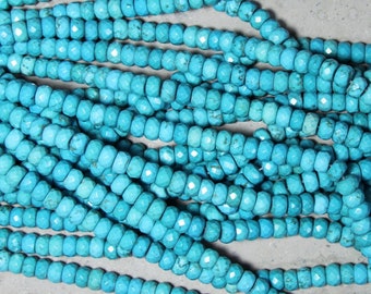 May include: A collection of bright turquoise blue beads arranged in multiple parallel strands. Each bead features a faceted, round shape with natural dark matrix inclusions visible throughout the surface, creating a textured appearance.