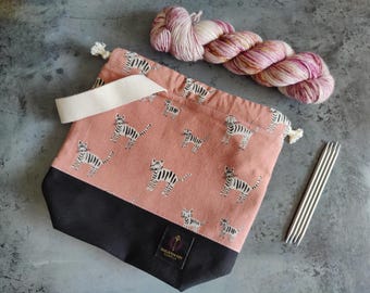 Small knitting or crochet project bag with interior pocket. Simple bag with wrist handle and drawstring closure. Modern handmade bag.