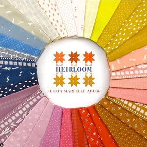 May include: A circular arrangement of folded fabric swatches in a spectrum of colours including blue, purple, pink, orange, yellow, and cream. The centre features the text HEIRLOOM and ALEXIA MARCELLE ABEGG with a geometric star-shaped graphic.