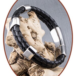 K&ouml;nnte beinhalten: Ein schwarzes Lederarmband mit silbernen Metallakzenten. Das Armband ist geflochten und hat einen Magnetverschluss.