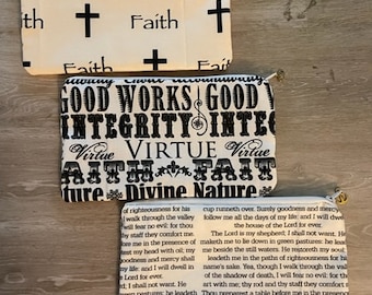 May include: Two white fabric pouches with zipper closures. The top pouch has a repeating pattern of black crosses and the word "Faith". The bottom pouch has a black and white pattern with the words "Good Works", "Integrity", "Virtue", and "Divine Nature".