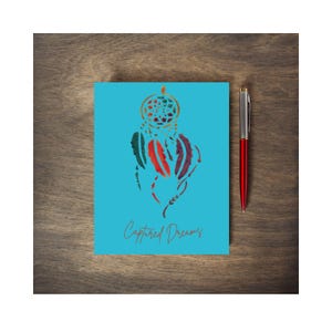 May include: A turquoise blue card with a colorful dreamcatcher design and the text "Captured Dreams".