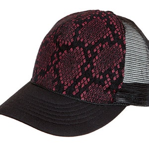 May include: A black and pink trucker hat with a snakeskin pattern. The hat has a mesh back and a black brim.