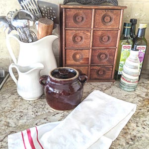 Vintage bonenpot van bruin geglazuurd steengoed: keukenfornuis uit het midden van de eeuw